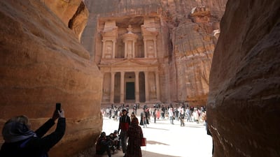 Tourists take pictures in front of the treasury site. Reuters