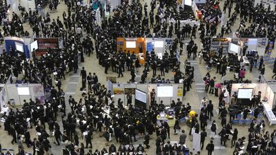Job seekers attend a job fair held for fresh graduates in Tokyo. Sluggish growth and easing price pressures due to sliding global oil prices prompted the Bank of Japan to unexpectedly expand its massive monetary stimulus last month. Yuya Shino / Reuters
