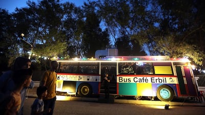 Pedestrians walk past "The Bus Cafe Erbil" in Erbil, the capital of Iraq's Kurdish autonomous region late on the long weekend of the Eid al-Fitr holiday. AFP