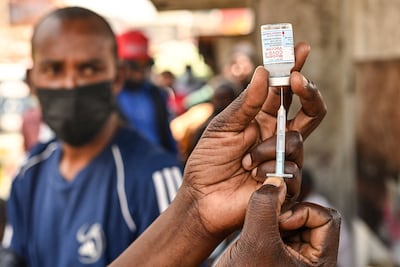 A health official prepares a Covid-19 vaccine prior to administering it during a mass vaccine drive in Kenya. AFP