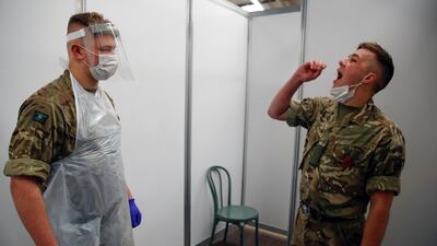 A soldier gives a swab sample at a testing centre in Liverpool. Reuters