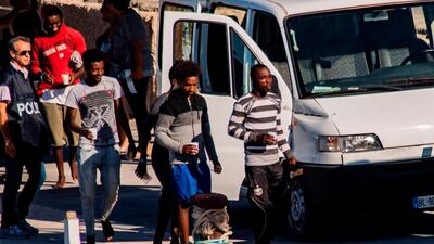 Twenty-seven unaccompanied minors are escorted to police vans as they prepare to leave the harbour in Lampedusa after being evacuated from the Spanish migrant NGO rescue ship Open Arms moored off the coast of the island. AFP / Alessandro SERRANO