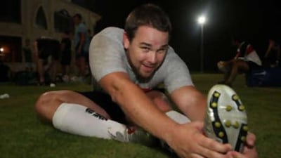The new club captain of the Abu Dhabi Harlequins rugby union team Peter Sampson stretches after a training session.