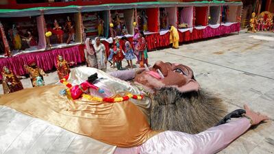 People look at an effigy of Putna, a female demon who according to Hindu epics tried to feed Hindu Lord Krishna poisoned milk, when the Lord was still a baby, at a temple during the Janmashtami festival marking the birth anniversary of Lord Krishna in Chandigarh. Ajay Verma / Reuters