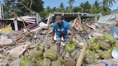A man salvages cooking gas cylinders from the ruins of a shop belonging to his brother-in-law in Pemenang, northern Lombok. AFP