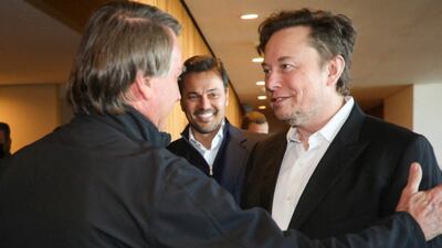 Mr Bolsonaro and Mr Musk greet each other in Sao Paulo. Reuters