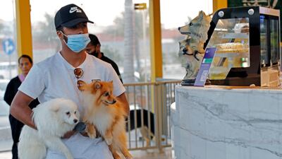 A customer carries his dogs at "Barking Lot" cafe where customers can bring their dogs, in Khobar, Saudi Arabia. Reuters