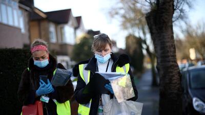 Workers look a list of addresses as they deliver home test kits for residents in Pollards Hill, London. Reuters
