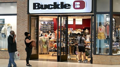 Shoppers wearing protective masks wait in line outside a Buckle store at the Galleria Dallas mall in Dallas, in the US. Restaurants, malls, and stores reopened in Texas on May 1, limited to 25 per cent occupancy. Bloomberg
