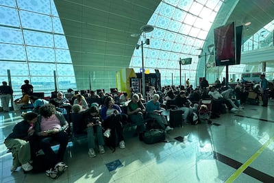 Dozens of passengers wait at Dubai Airport as flights were delayed or cancelled due to heavy rain. AFP