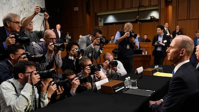 Boeing chief executive Dennis Muilenburg, right, sits before the start of a Senate Committee hearing on the company's 737 Max and aviation safety on Tuesday. AP Photo