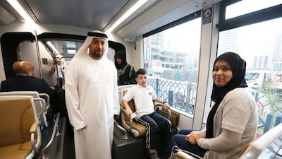 Abu Rashid, left, his daughter Shahd, right, and son Rashid, centre, take a ride on the Dubai Tram on its first day of service. Pawan Singh / The National
