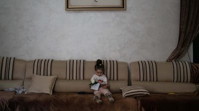 Karmel, 3, sits in the living room playing with a mobile phone in a respite from confrontations between Palestinian protesters and Israeli forces in Bethlehem. She collapsed in her home after inhaling tear gas fired by Israeli soldiers two days earlier. Getty Images