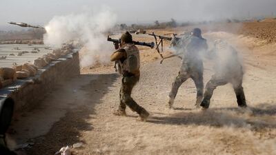 An Iraqi soldier fires a RPG during clashes with ISIL fighters in Al-Qasar.