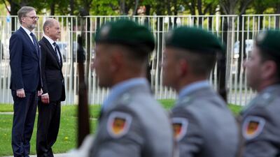 Chancellor Olaf Scholz, on podium at right, could go down as one of the most important and unlikely military reformers in Germany's history. AP