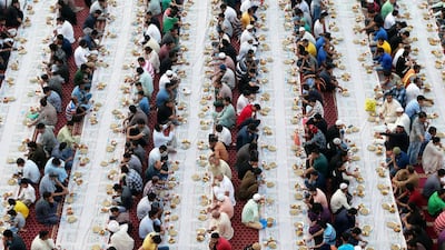People sit together to break their fast in the parking area near the Al Ghubaiba Bus Station in Bur Dubai. Pawan Singh / The National