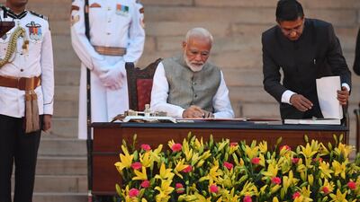 Narendra Modi signs documents after taking the oath of office as India's Prime Minister at the President house in New Delhi on May 30, 2019. AFP Photo