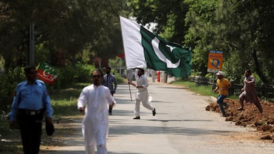A supporter of ruling party Pakistan Tehreek-E-Insaf holds the national flag during a protest in Islamabad, Pakistan, on April 3. AP