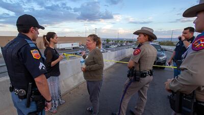 Edie Hallberg, third from left, speaks with police officers outside the Walmart store as she's looking for her missing mother Angie Englisbee, 87, who was in the store during the shooting in El Paso, Texas. AP Photo