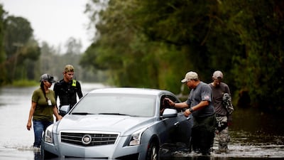 Members of a private critical crisis search and rescue team inspect a vehicle partially submerged in floodwaters during Tropical Storm Florence in Beulaville, North Carolina. Bloomberg