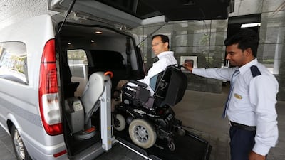 Scott Sankey, a Canadian expatriate, is assisted on to one of the Mercedes Vito Compact taxis in Abu Dhabi. Pawan Singh / The National