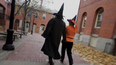 Two people in witch costumes walk along the street next to the old Town Hall in Salem, Massachusetts. Joe Raedle / Getty Images