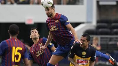 ARLINGTON, TX - AUGUST 06: Gerard Pique #3 of FC Barcelona heads the ball against Daniel Montenegro #10 of Club America at Cowboys Stadium on August 6, 2011 in Arlington, Texas. Ronald Martinez/Getty Images/AFP== FOR NEWSPAPERS, INTERNET, TELCOS & TELEVISION USE ONLY == *** Local Caption *** 565098-01-09.jpg