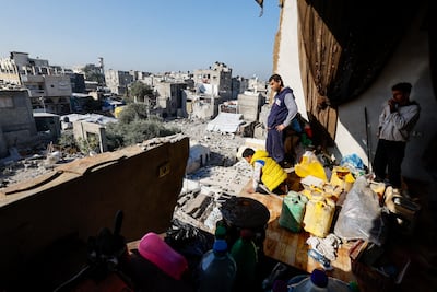 Palestinians look at the site after a building in Gaza previously damaged by Israeli strikes collapsed. Reuters