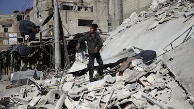 A boy stands on the rubble of a damaged building at the besieged town of Douma, Eastern Ghouta, Damascus, Syria on March 5, 2018. Bassam Khabieh / Reuters