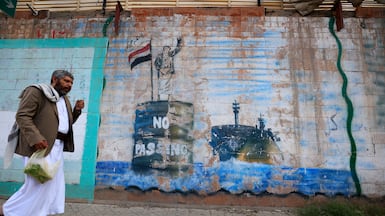 Graffiti in Sanaa depicts a Houthi fighter stopping a ship off the coast of Yemen. EPA