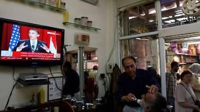 Palestinians at a barber shop in East Jerusalem watch Barack Obama deliver his landmark speech at Cairo University in 2009. Ahmad Gharabli / AFP