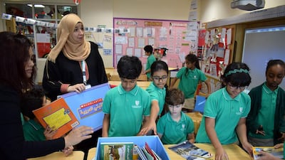 Students at Al Yasmina School receive books from Scholastic as part of the #UAEReads Challenge. Arabic teacher Nagat Eid, left, says the challenges given to her young readers at schools maintain their interest in literacy. Delores Johnson / The National
