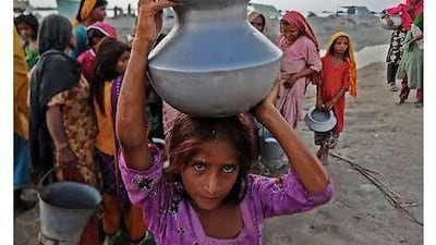A girl displaced by flooding collects drinking water from a pump at a relief camp north of Dadu, Sindh province, this week.