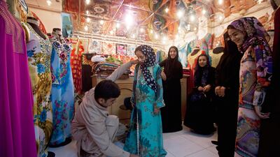 Ajman, August 8, 2011 - Shamma Al Baluchi is measured for a new dress she will wear for EID while her sisters Khadijah, Sara, her aunt Balkees Al Baluchi and her sister Mariam watch in the Al Emad Tailoring shop in the Gold Souk area in Ajman City. The fa???