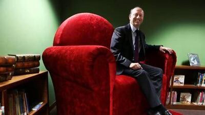 Paul Coackley, principal at the British School Al Khubairat, seated in the oversized chair that is an instantly recognisable feature of the new primary school library. Delores Johnson / The National
