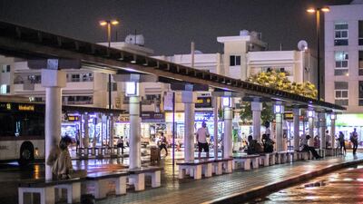 Passengers wait at Satwa's existing bus station on a rainy evening. Reem Mohammed / The National