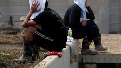Local residents pause as they try to clean debris from their house in Kurashiki, Okayama. Reuters