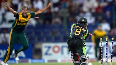 Pakistan's batsman Mohammad Hafeez, right, is clean bowled by South African bowler Imran Tahir during the fourth day-night international at Sheikh Zayed Cricket Stadium in Abu Dhabi Friday. South Africa leads the five-match series 3-1. Asif Hassan / AFP
