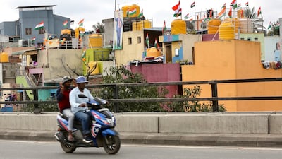 A scooter rides past houses flying the Indian tricolour in Bangalore. Prime Minister Narendra Modi's Har Ghar Tiranga campaign had urged Indians to hoist the national flag to mark Independence Day. EPA