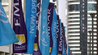 EMAAR property flags flutter in the breeze on a bridge in the Dubai Marina.