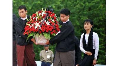 Aung San Suu Kyi arrives with a wreath to pay her respects to her father, the late General Aung San, and eight other leaders who were assassinated on July 19, 1947, at the official ceremony marking the 64th anniversary of Martyrs' Day at a mausoleum near the Shwe Dagon Pagoda in Yangon yesterday.