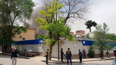 Afghan security personnel watch as smoke rises after the explosion. AP