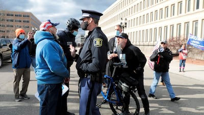 Michigan State Police separate a counter protestor from U.S. President Donald Trump's supporters as the Board of State Canvassers meet to certify the results of the election in Lansing, Michigan. Reuters