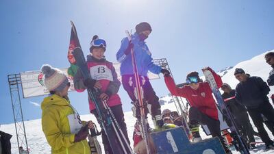 Nazira (first) helps Taybea (third) onto the podium. Rick Findler for The National