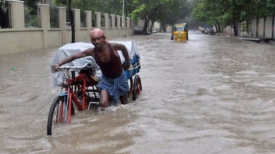 A man pushes his cycle trishaw through floodwaters in Chennai, southern India. AFP Photo