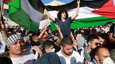 Protesters wave Palestinian flags as they gather for a demonstration in solidarity with the Palestinian people, near the Israeli embassy, in Jordan's capital Amman. AFP