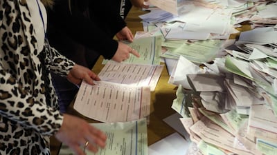 Members of a local electoral commission count ballots at a polling station during the first round of Lithuania's presidential election at a polling station in Vilnius, Lithuania. AFP