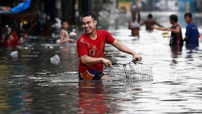A Filipino rides his bicycle through floodwaters in Quezon City. Rolex De La Pena / EPA