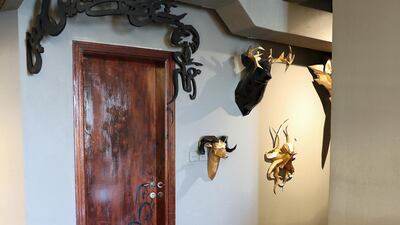 A calligraphy extract by poet Allama Iqbal starts an an archway above a door before working its way down to the floor and onto a green leather chair. Pawan Singh / The National