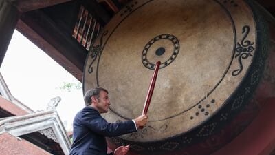 French President Emmanuel Macron beats a drum at Van Mieu temple in Hanoi during his first official trip to Vietnam. AP